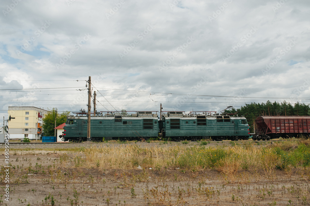 Train locomotive with wagons riding railroad in the forest. Low-speed railroad. Speed industrial post. Train locomotive with wagons riding railroad in the forest. Low-speed railroad. Speed industrial post.