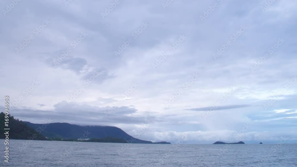 A wide shot of the mountains and sky and ocean. Panning shot to the right.