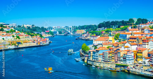 Beautiful panoramic view over Dom Luis I bridge and traditional boats on Rio Douro river in Porto, Portugal photo