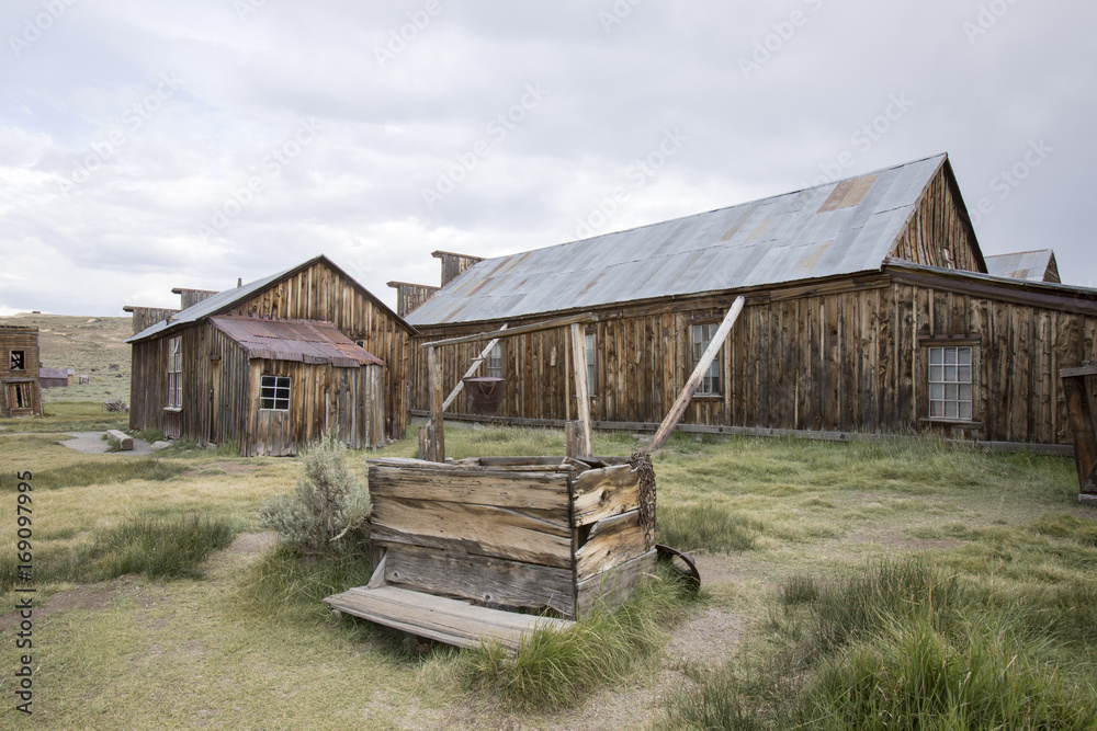 Wooden well and barn in field, Bodie Wooden well and barn in field, Bodie