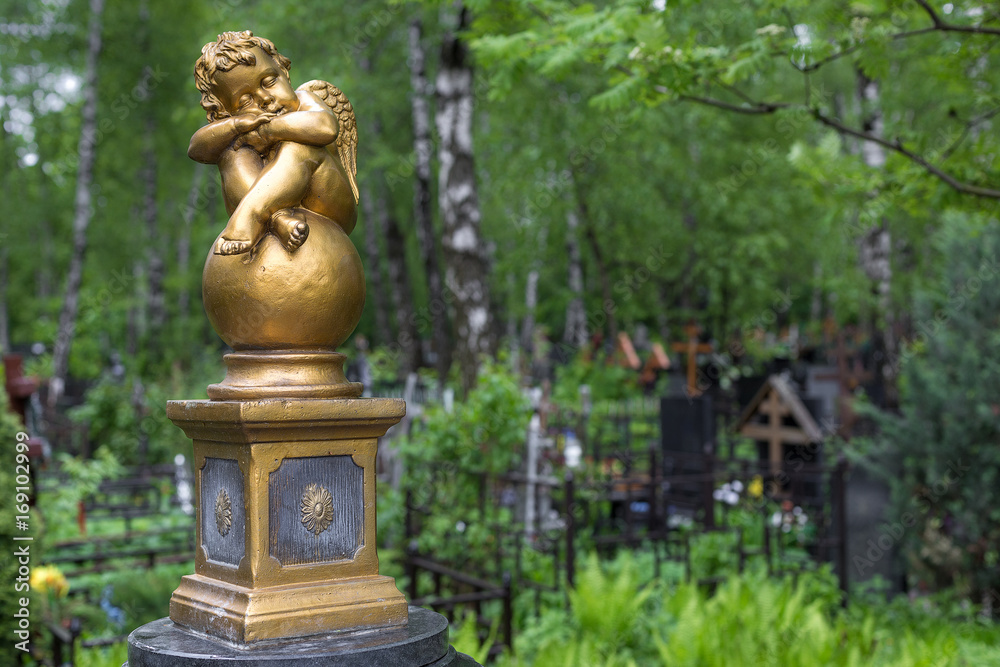 little angel sit on the ball on cemetery