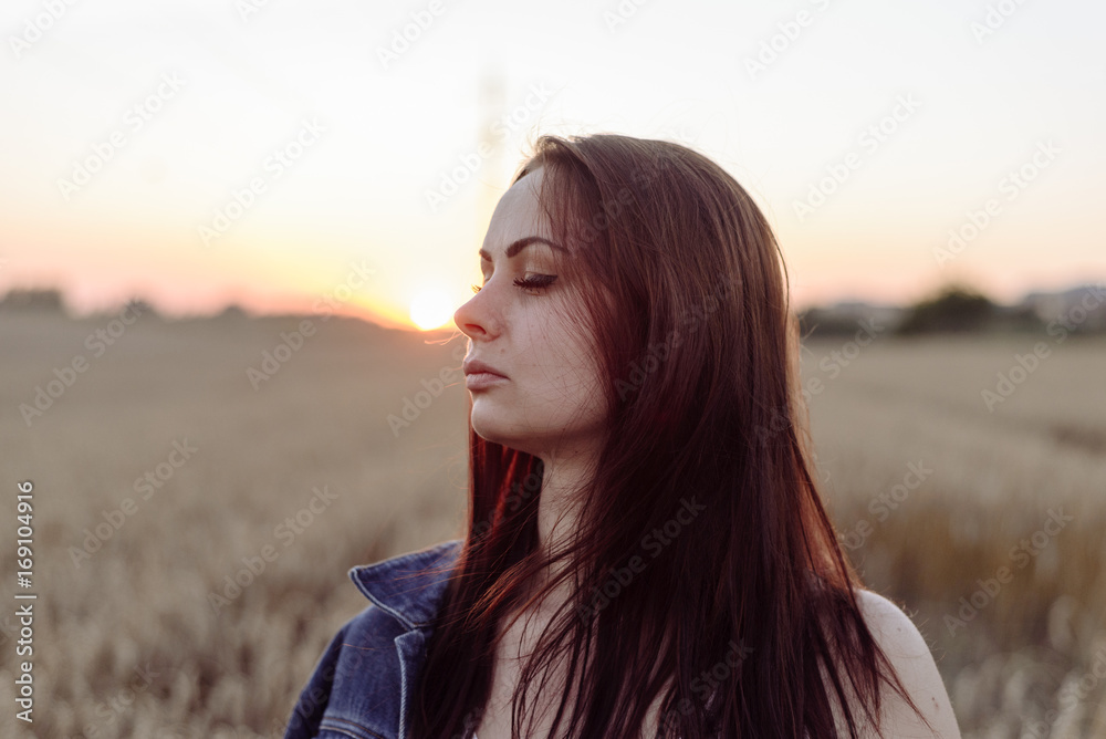 Portrait of happy young beautiful woman brunette in field wheat sunset evening