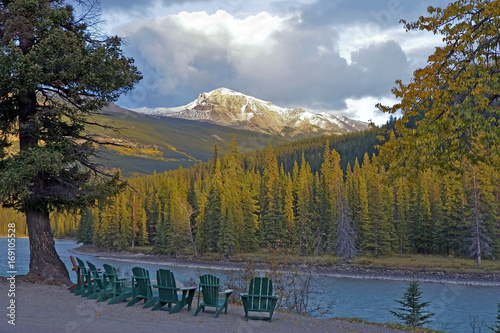 Chairs along Athabasca River with view of snow capped Mountain Peaks, Jasper National Park Alberta Canada