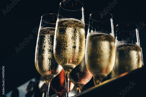 a row of glasses filled with champagne are lined up ready to be served photo