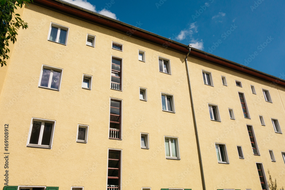 Fototapeta premium yellow apartment house with blue sky