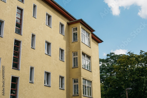 yellow corner building with glass balconies