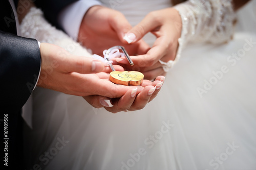 The bride and groom hold a lock in the form of a heart, as a symbol of a strong marriage...