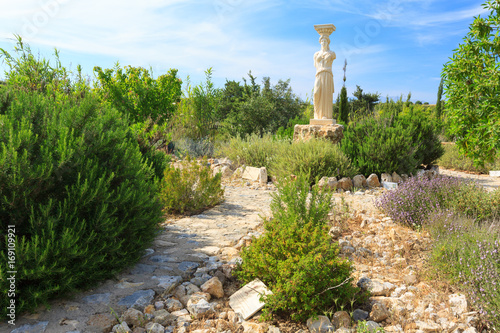 Garden with stones and greek goddess statue. photo