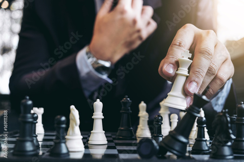 Close up of hands confident businessman colleagues playing chess game to development analysis new strategy plan, leader and teamwork concept for success.