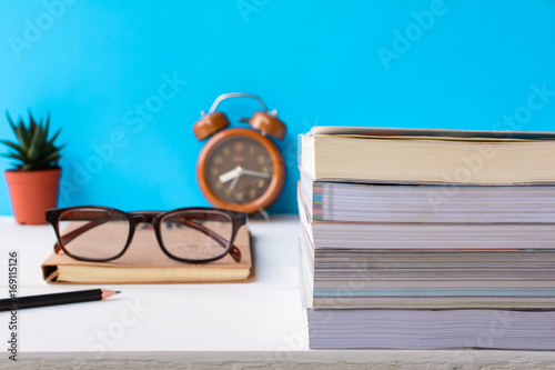 Books and glasses on a white wooden table are clocks and decorations With a room