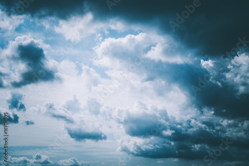 Dunkle Wolken bei blauem Himmel und Sonnenschein mit dramatischer Atmosphäre fotografiert
