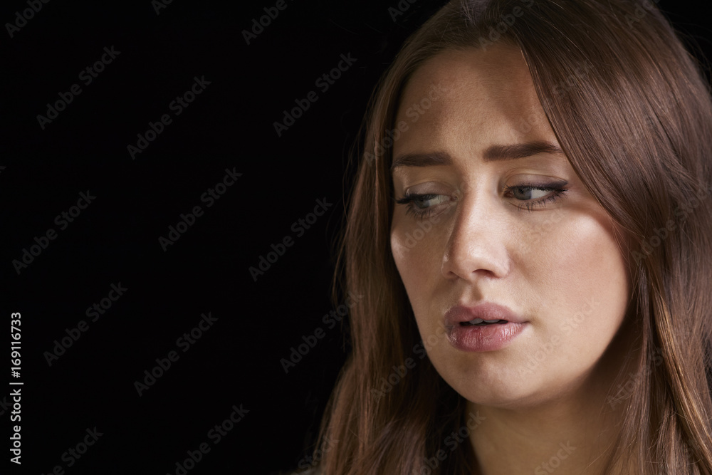 Close Up Head And Shoulders Studio Shot Of Anxious Woman