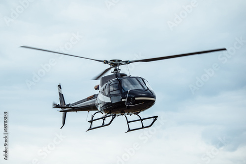 Fototapeta Naklejka Na Ścianę i Meble -  Black tourist helicopter flying