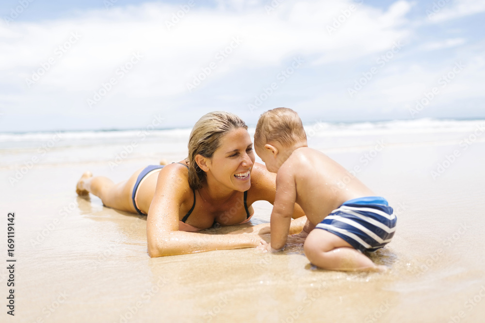 Mother playing with son (12-17 months) on beach Mother playing with son (12-17 months) on beach