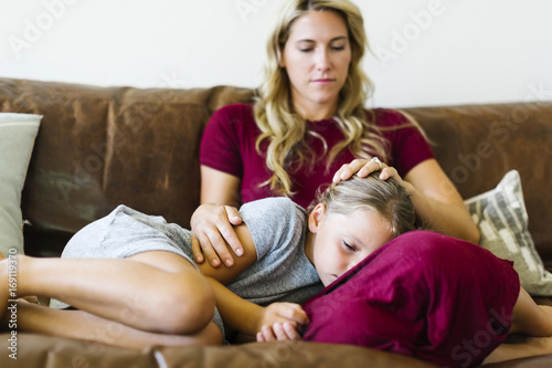 Woman sitting with daughter (6-7) on couch photo