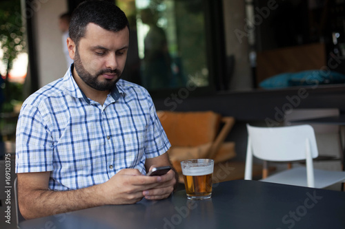 Bearded man using mobile phone in bar