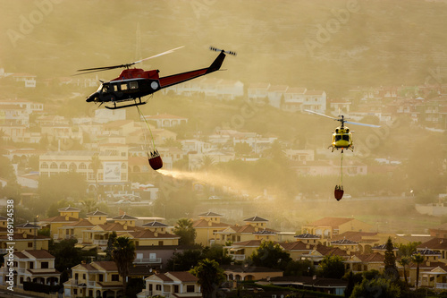 Two firefighter helicopters extinguishing a fire