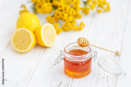 Useful honey and lemon. Honey dipper. The concept of healthy food, vegetarianism, autumn, colds,  treatment, cure, therapy, medication.