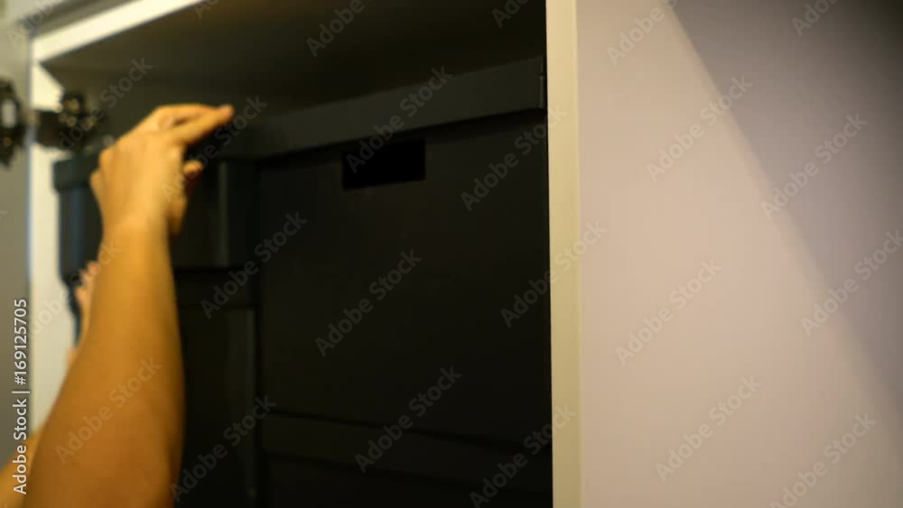 Hands of female searching in the black boxes on the shelves Hands of female searching in the black boxes on the shelves