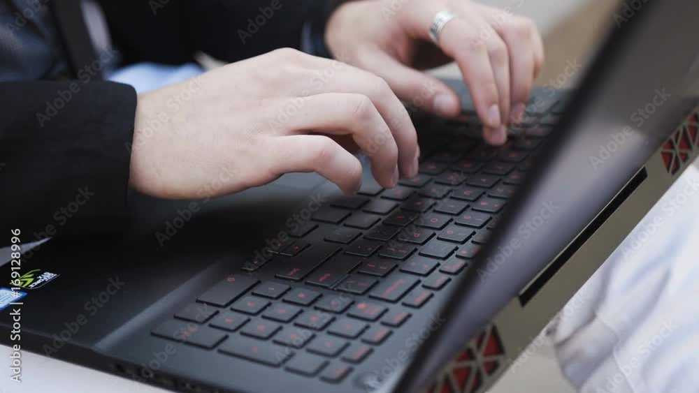 A young man in the open air is working on a computer A young man in the open air is working on a computer