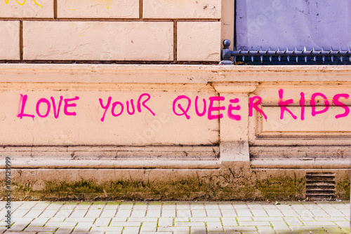 Pink graffiti on a wall saying 