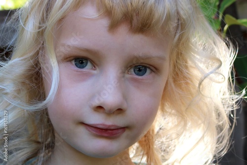 Canvas Print Close up portrait of a young girl with big blue eyes and golden curls