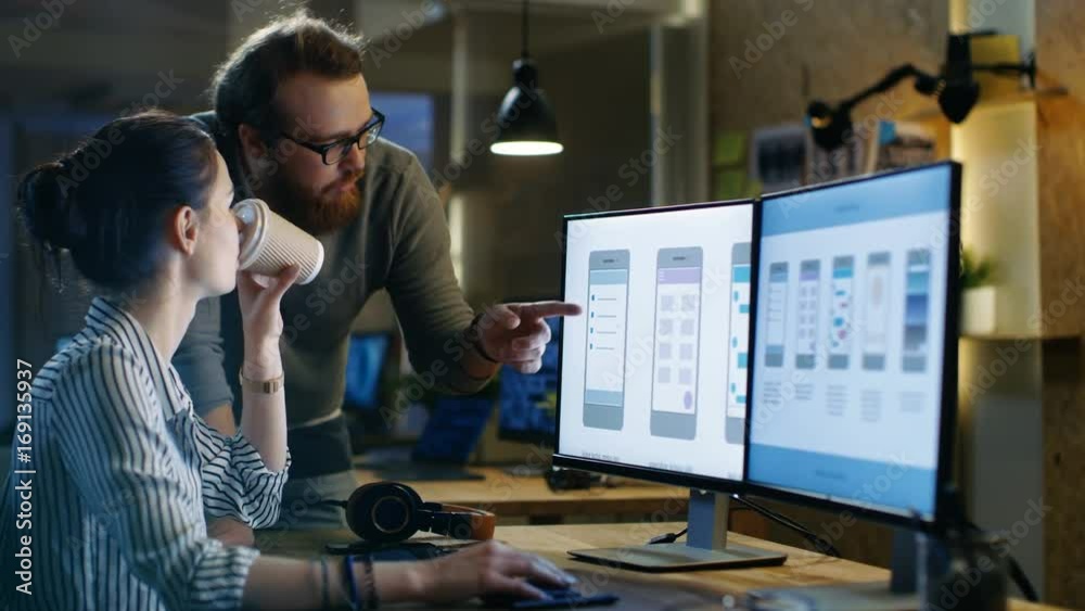 Female UX Architect Consults Male Design Engineer, They Work on Mobile Application in a Creative Office Space. Shot on RED EPIC-W 8K Helium Cinema Camera.
