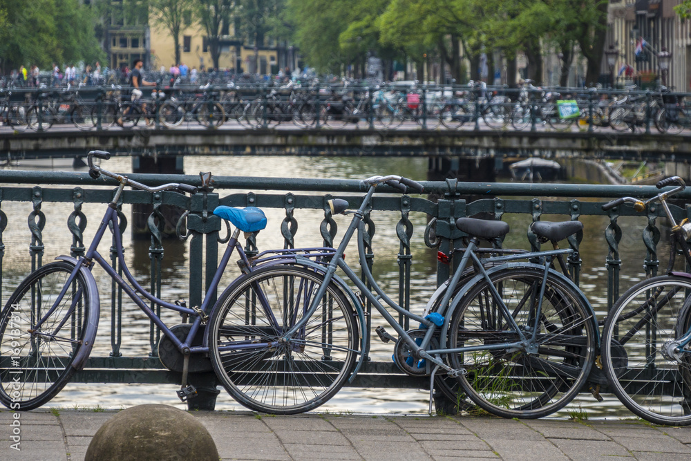 Typical for Amsterdam - bikes attached to a bridge - AMSTERDAM - THE NETHERLANDS - JULY 20, 2017