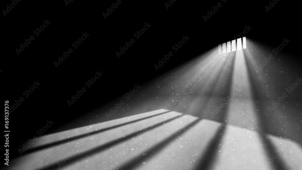 An old jail cell interior with barred up window with light rays penetrating through it reflecting the image on the floor