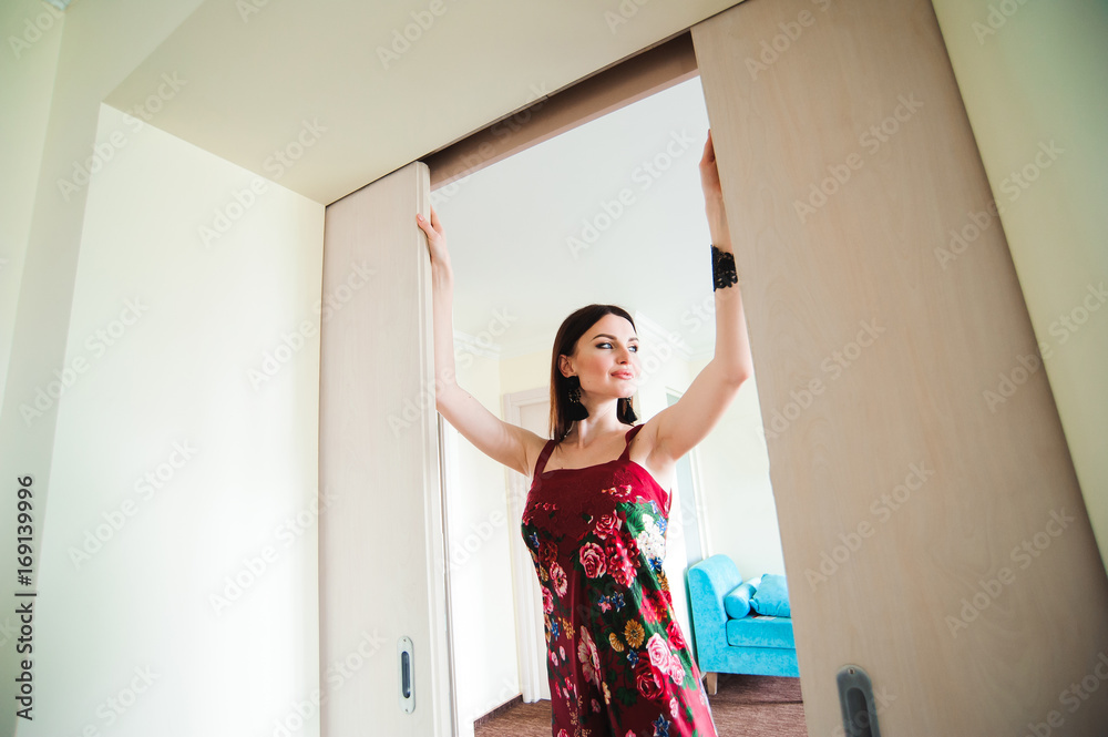Fototapeta premium Young woman opening door at modern hotel room