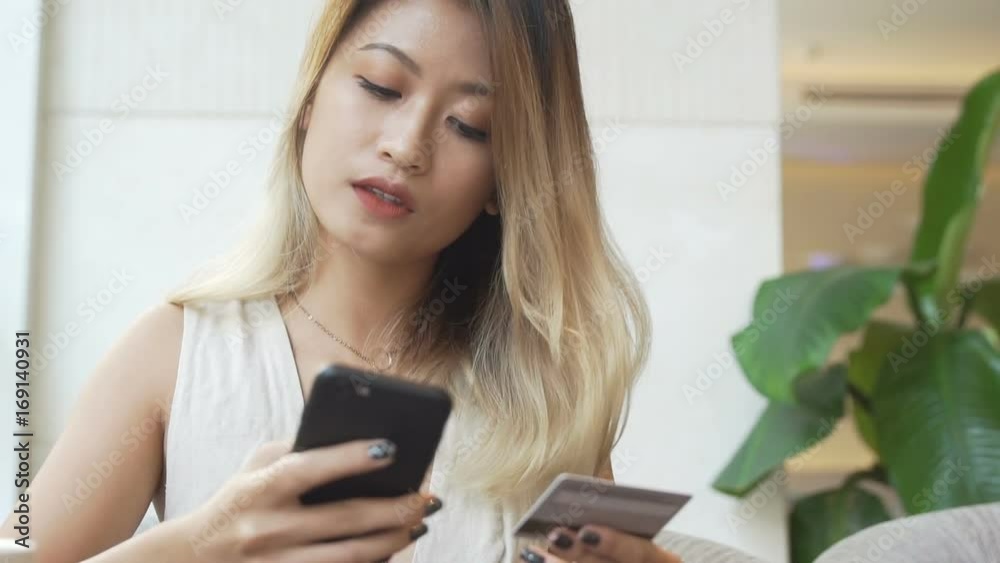 Woman buy new dress online using smartphone and credit card Woman buy new dress online using smartphone and credit card
