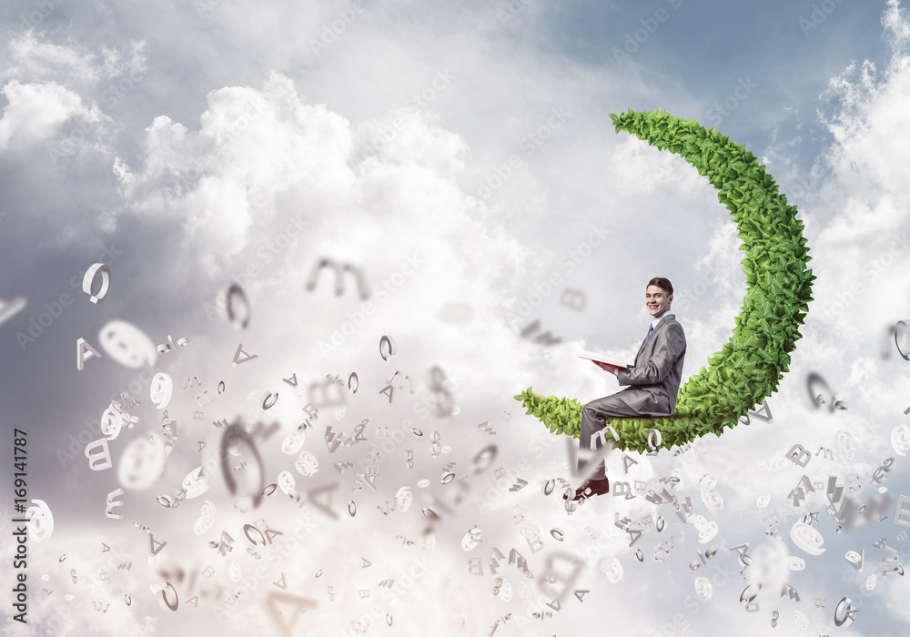 Man or student sitting on green moon and reading book Man or student sitting on green moon and reading book