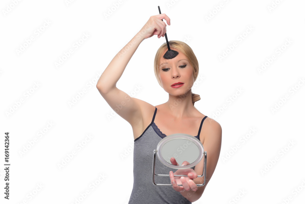 A young woman applying makeup on her face A young woman applying makeup on her face