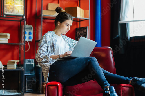 Businesswoman working on laptop in a creative office. photo