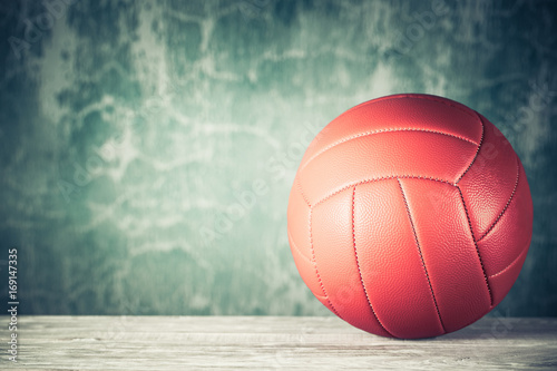 Retro leather ball on wooden floor front grunge aged background. Vintage style filtered photo photo