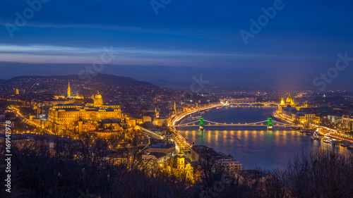 Budapest, Hungary - The beautiful illuminated Historic Royal Palace or Buda Castle with Szechenyi Chain Bridge, Parliament and Matthias Church and the Buda Hills at blue hour
