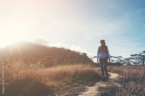 Hikers women walking through a meadow on mountain with sunrise