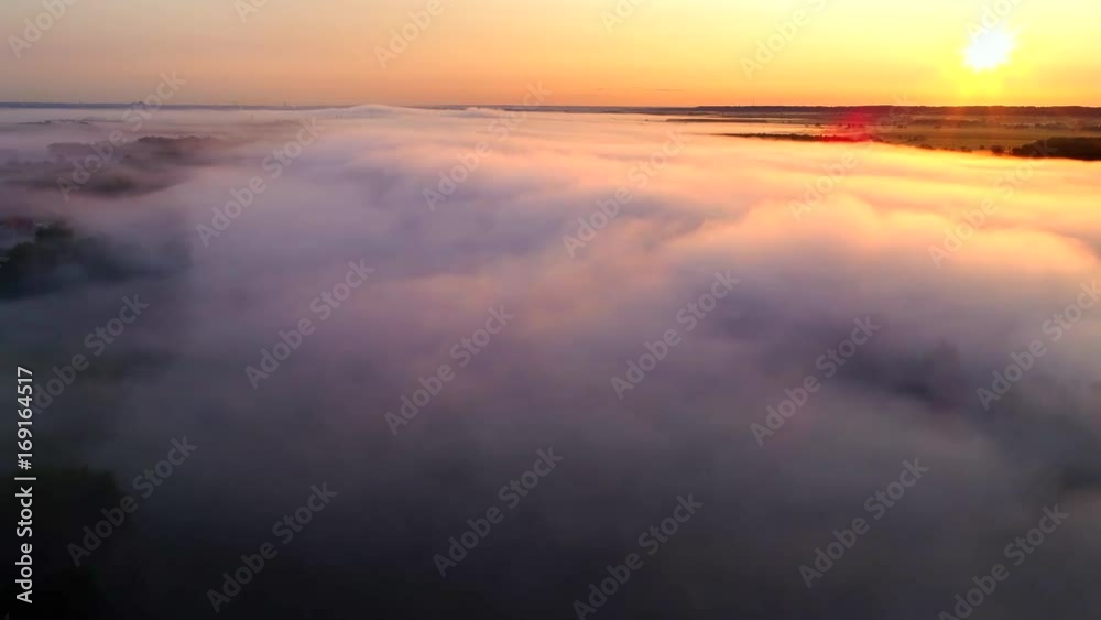 Rural landscape shrouded in ethereal fog at sunrise, aerial view.
Rural landscape shrouded in ethereal fog at sunrise, aerial view.