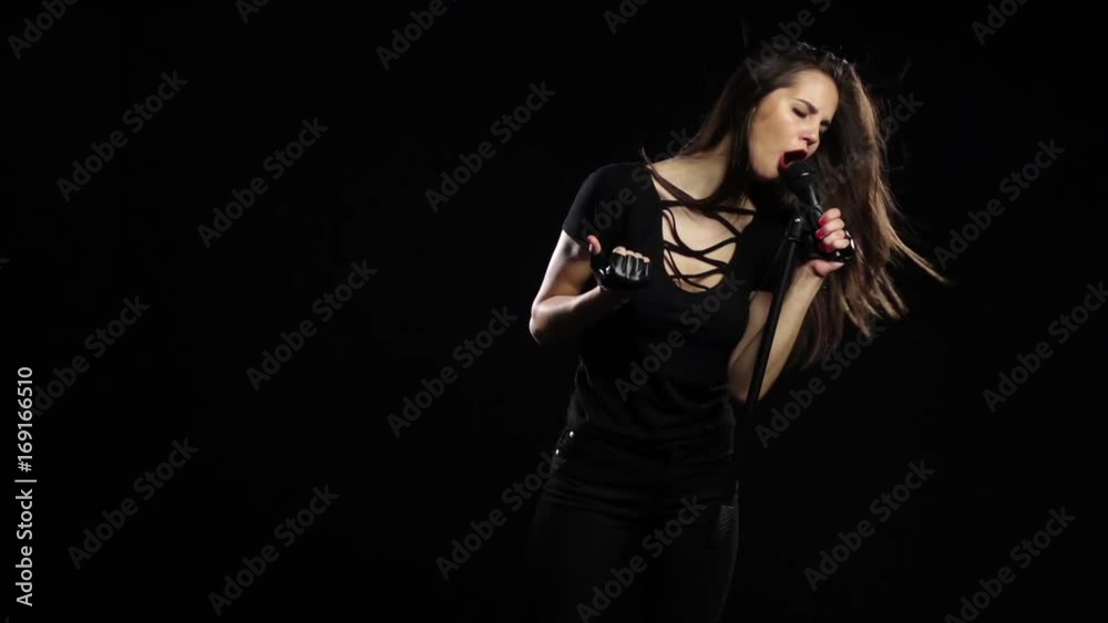 Singer sexually dances and sings songs in a microphone at a concert. Black background. Slow motion Singer sexually dances and sings songs in a microphone at a concert. Black background. Slow motion