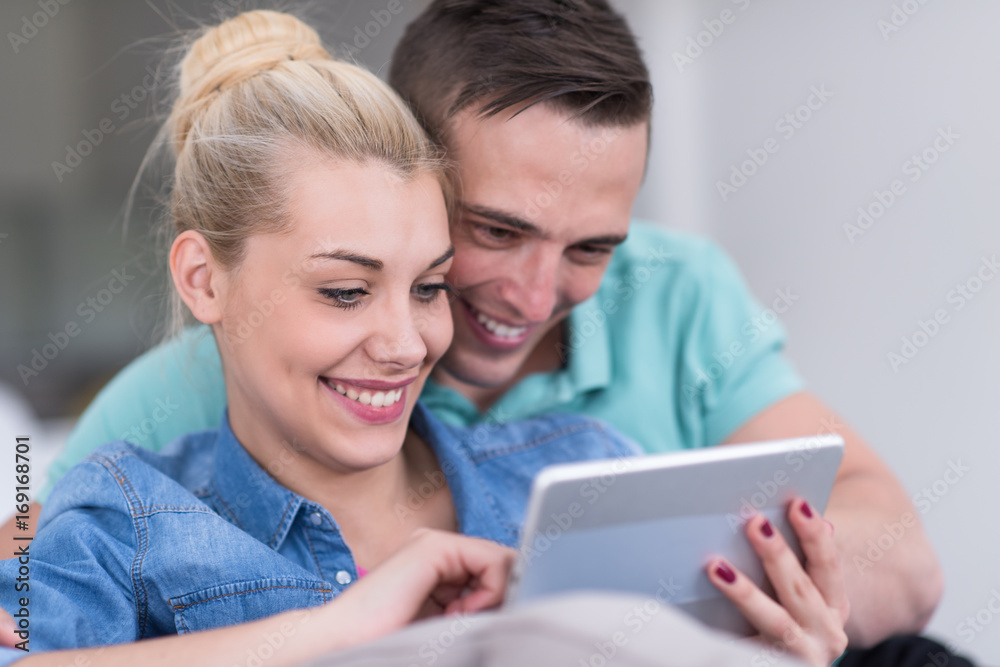 couple relaxing at home with tablet computers couple relaxing at home with tablet computers