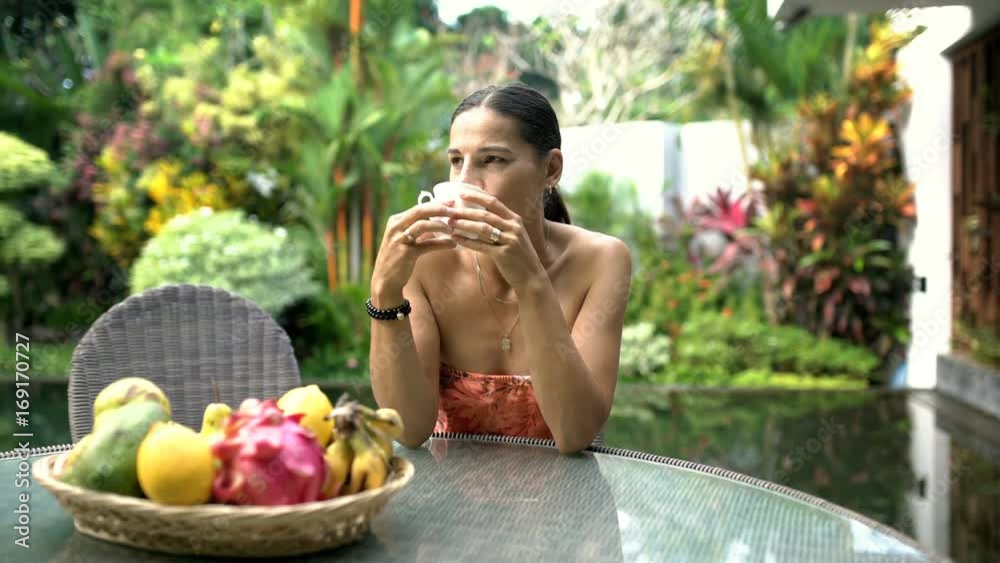 Attractive woman looks happy while drinking coffee and relaxing in exotic place, steadycam shot
Attractive woman looks happy while drinking coffee and relaxing in exotic place, steadycam shot