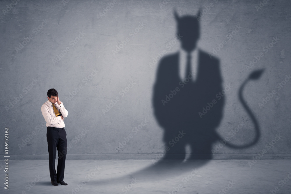 Obraz premium Business man looking at his own devil demon shadow concept