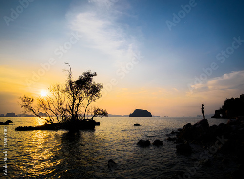 Silhouette of young woman looking at the sunset on the sea. Low-key image with small vignette. Krabi, Thailand photo