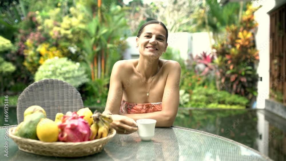 Attractive woman smiling to the camera and drinking coffee in exotic place, steadycam shot
Attractive woman smiling to the camera and drinking coffee in exotic place, steadycam shot