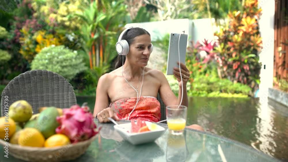 Attractive tanned woman sitting next to the pond and having a videocall on tablet, steadycam shot
Attractive tanned woman sitting next to the pond and having a videocall on tablet, steadycam shot
