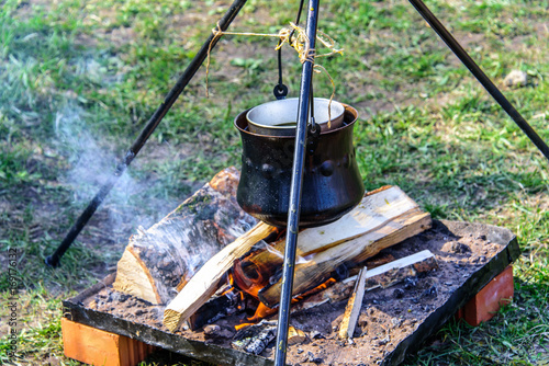 The metal cauldron hanging on a tripod over an open fire at the international knight festival Tournament of Saint George in the Kolomenskoye museum-reserve