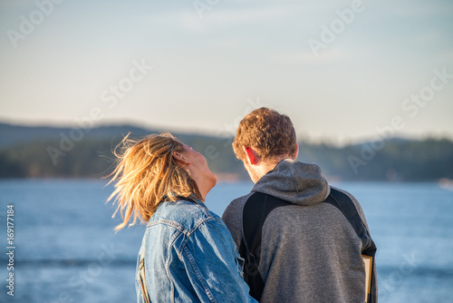 Back view of a young couple enjoying outdoor relax with beautiful landscape