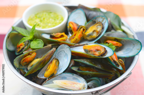 Thai Food steamed mussels with basil and lemongrass. Eaten with spicy sauce.