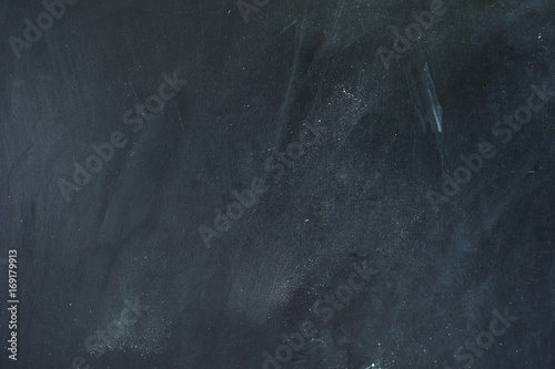 Black chalkboard background texture with chalk dust.