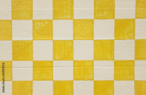 Yellow and white checkerboard design on wood panel background